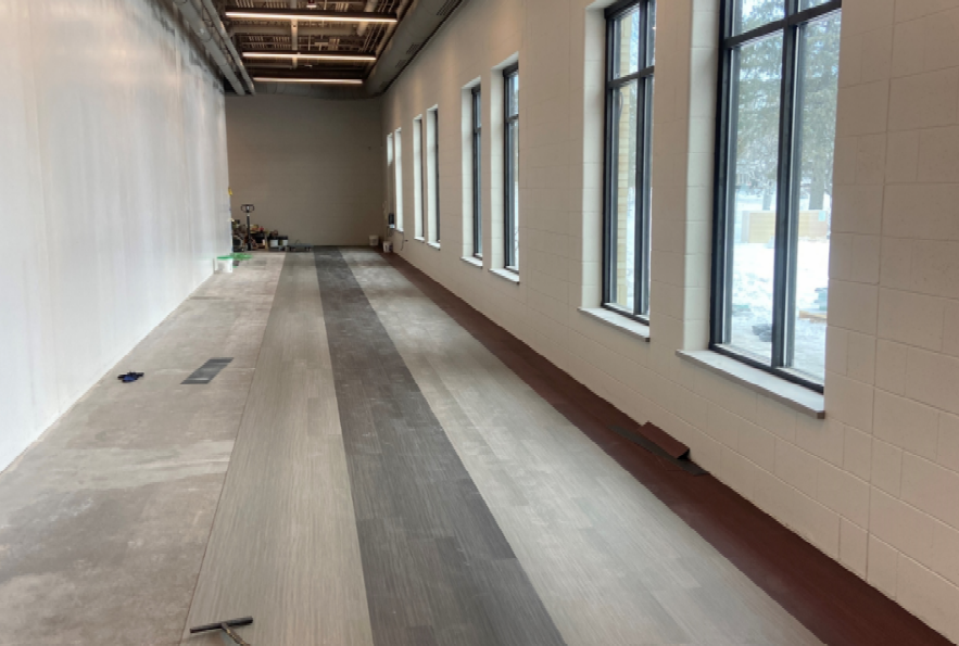 The luxury vinyl tile installation has begun in the south corridor