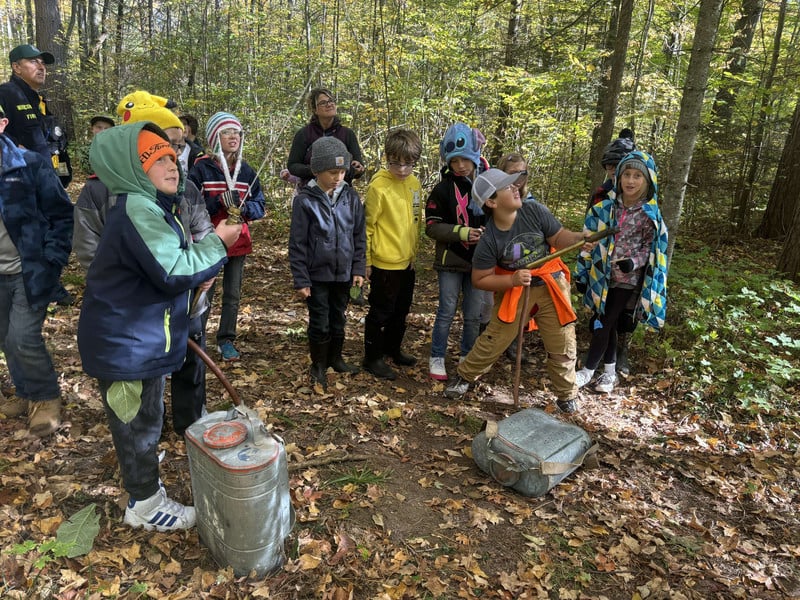 Elementary students spraying water in the woods