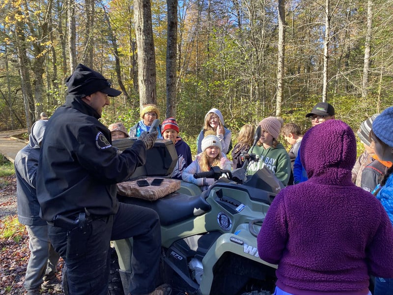 Students learning from the local DNR around his four wheeler