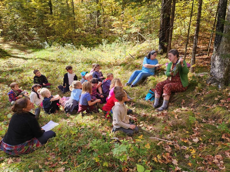 Mrs. Paul's class enjoying a book in the forest