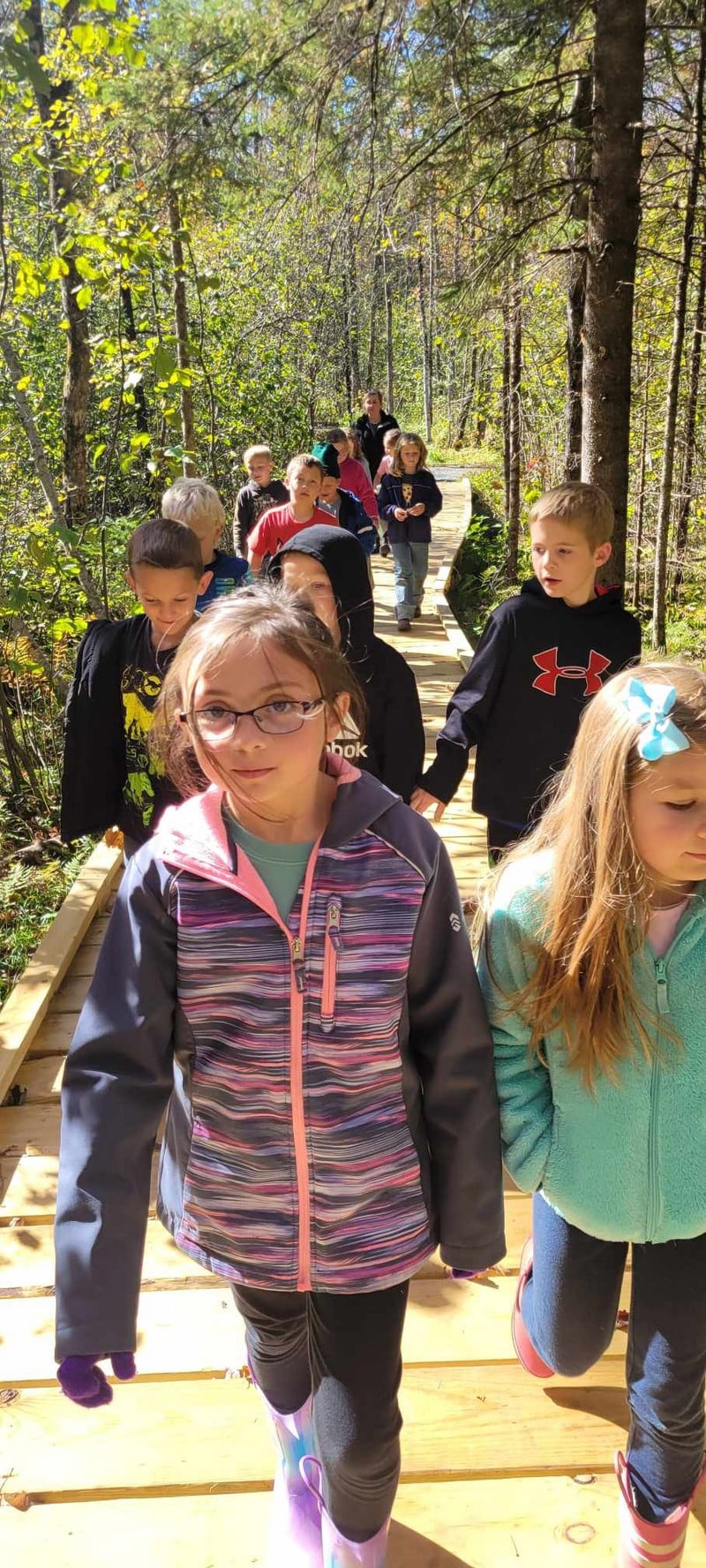 Elementary students walking along the boardwalk in sunshine