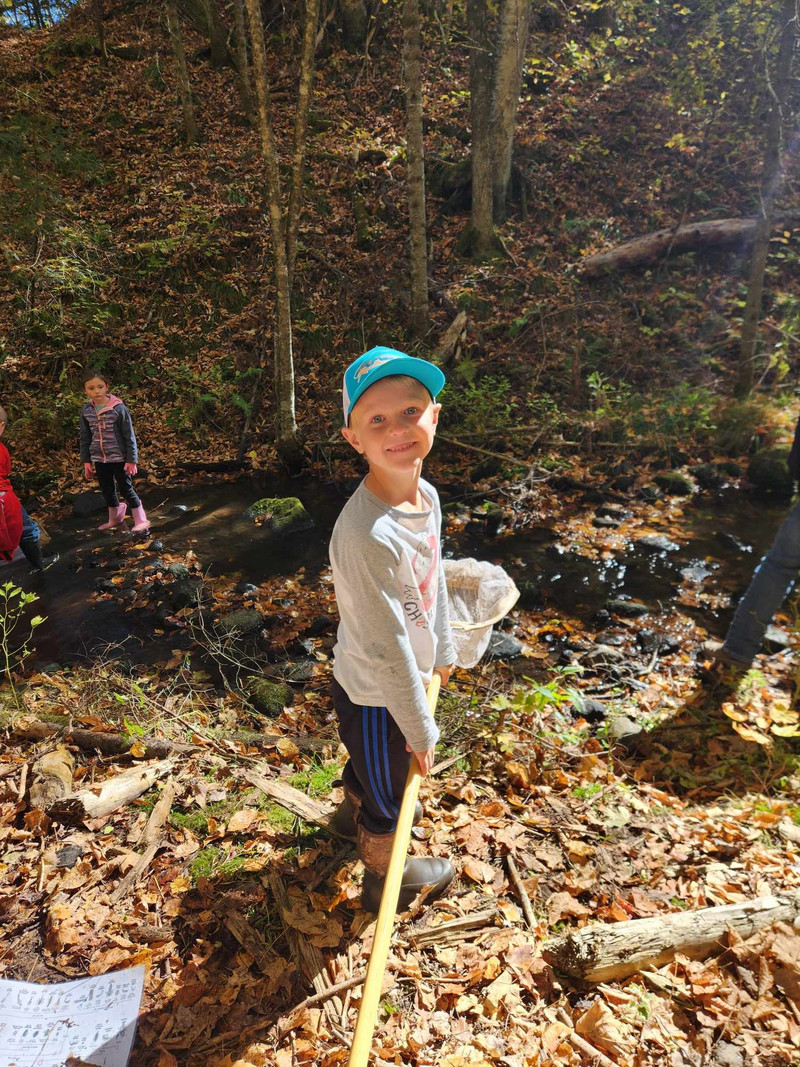 Elementary student ready to use his net to catch insects in the creek