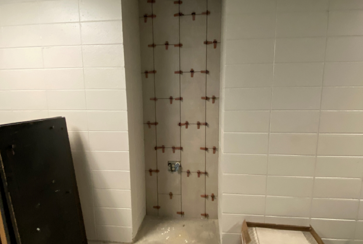The wall tile behind the existing middle school water fountain has been installed.