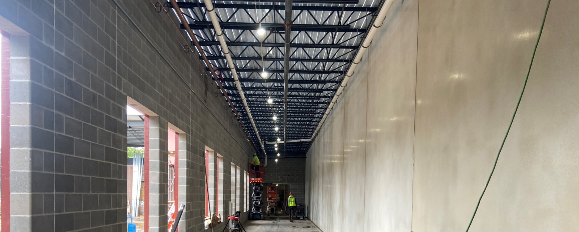 Addition corridor with overhead plumbing and fire protection.
