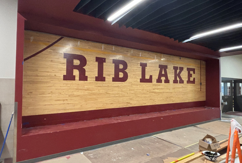 The existing gym floor cutout has been set into place as the background of the addition trophy case.