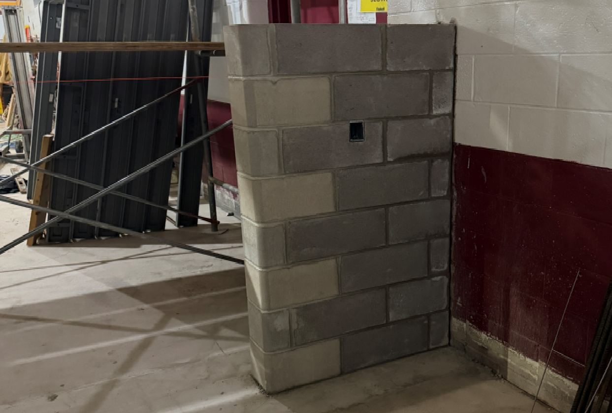 The masons have begun working on the opening between the new band room and band storage