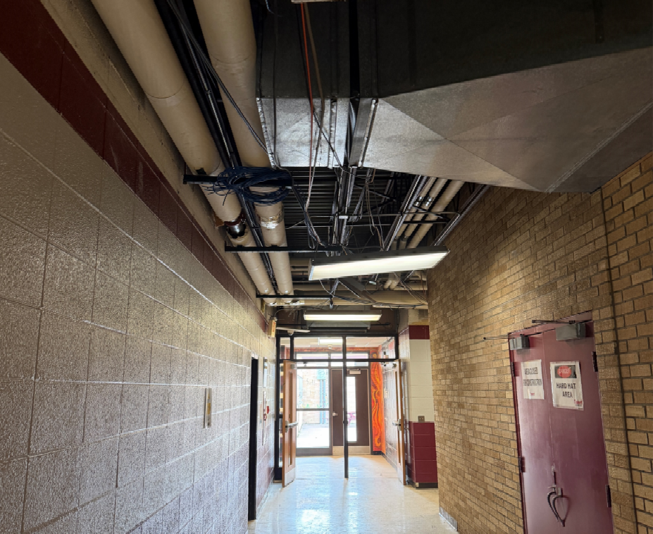 Existing ceiling tiles have been removed from the corridors outside of the band room to allow for mechanical piping installation